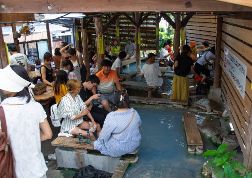 Tourists in gensen kakenagashi footbath area in Kamado jigoku, Oita Prefecture, Beppu, Japan