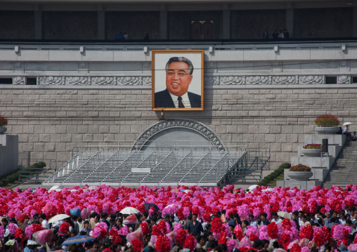 North Korean people with plastic bunches of red flowers celebrating the 60th anniversary of the regim, Pyongan Province, Pyongyang, North Korea