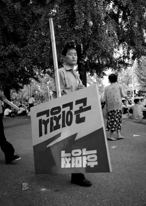 North Korean man carrying a propaganda billboard in the street, Pyongan Province, Pyongyang, North Korea