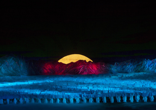 North Korean dancers in front of rising sun over mount Paektu made by children holding up boards during Arirang mass games in may day stadium, Pyongan Province, Pyongyang, North Korea