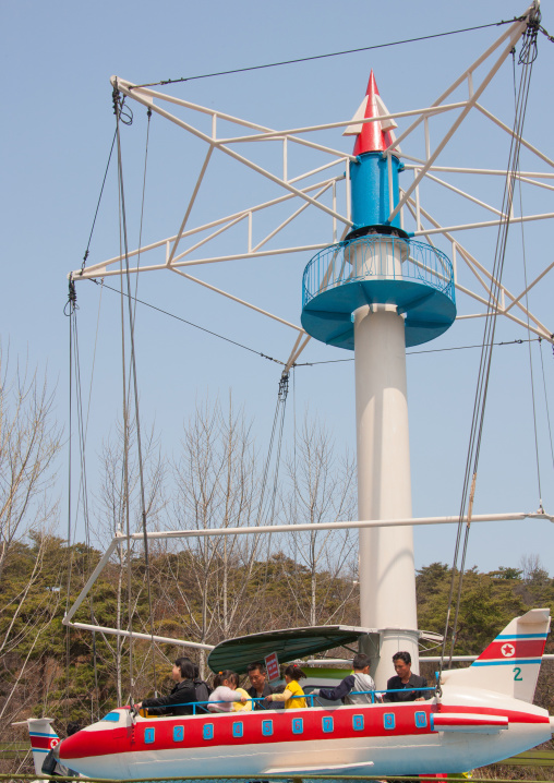 North Korean people having fun on a plane attraction in Taesongsan funfair, Pyongan Province, Pyongyang, North Korea