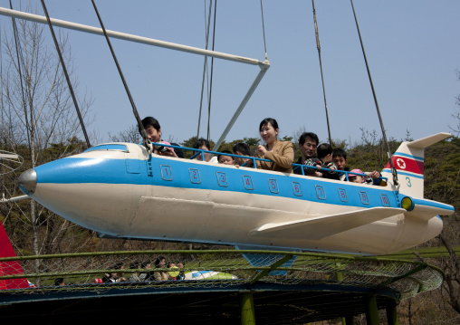 North Korean people having fun on a plane attraction in Taesongsan funfair, Pyongan Province, Pyongyang, North Korea