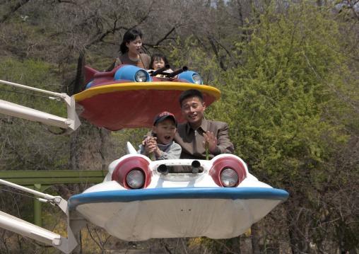 North Korean people having fun on a flying saucer attraction in Taesongsan funfair, Pyongan Province, Pyongyang, North Korea