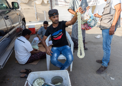 A saudi flower vendor preparing floral garlands and crowns on a market, Jizan Province, Sabya, Saudi Arabia