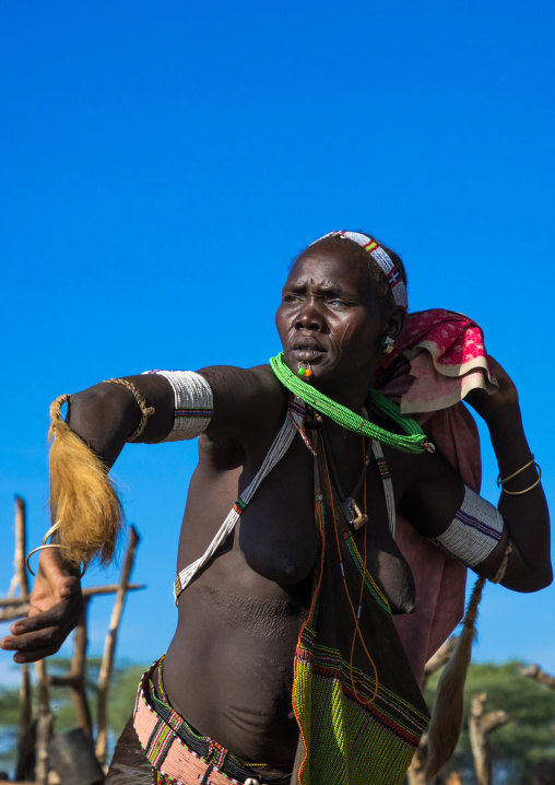 Toposa tribe woman in traditional clothing dancing during a ceremony, Namorunyang State, Kapoeta, South Sudan