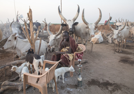 Mundari tribe man smoking shisha in a cattle camp, Central Equatoria, Terekeka, South Sudan