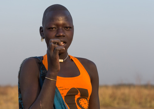 Mundari tribe woman using a wooden toothbrush, Central Equatoria, Terekeka, South Sudan